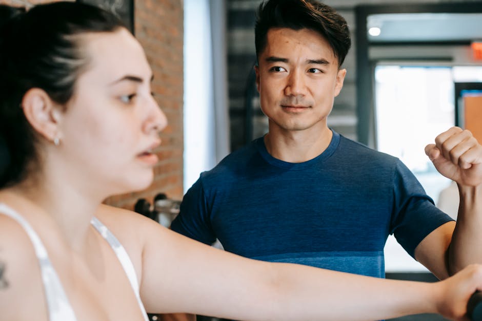 Un coach sportif échange avec un client dans une salle de sport, posant des questions et présentant un programme d’entraînement, illustrant la proximité et la personnalisation du métier.créer un site internet pour coach sportif